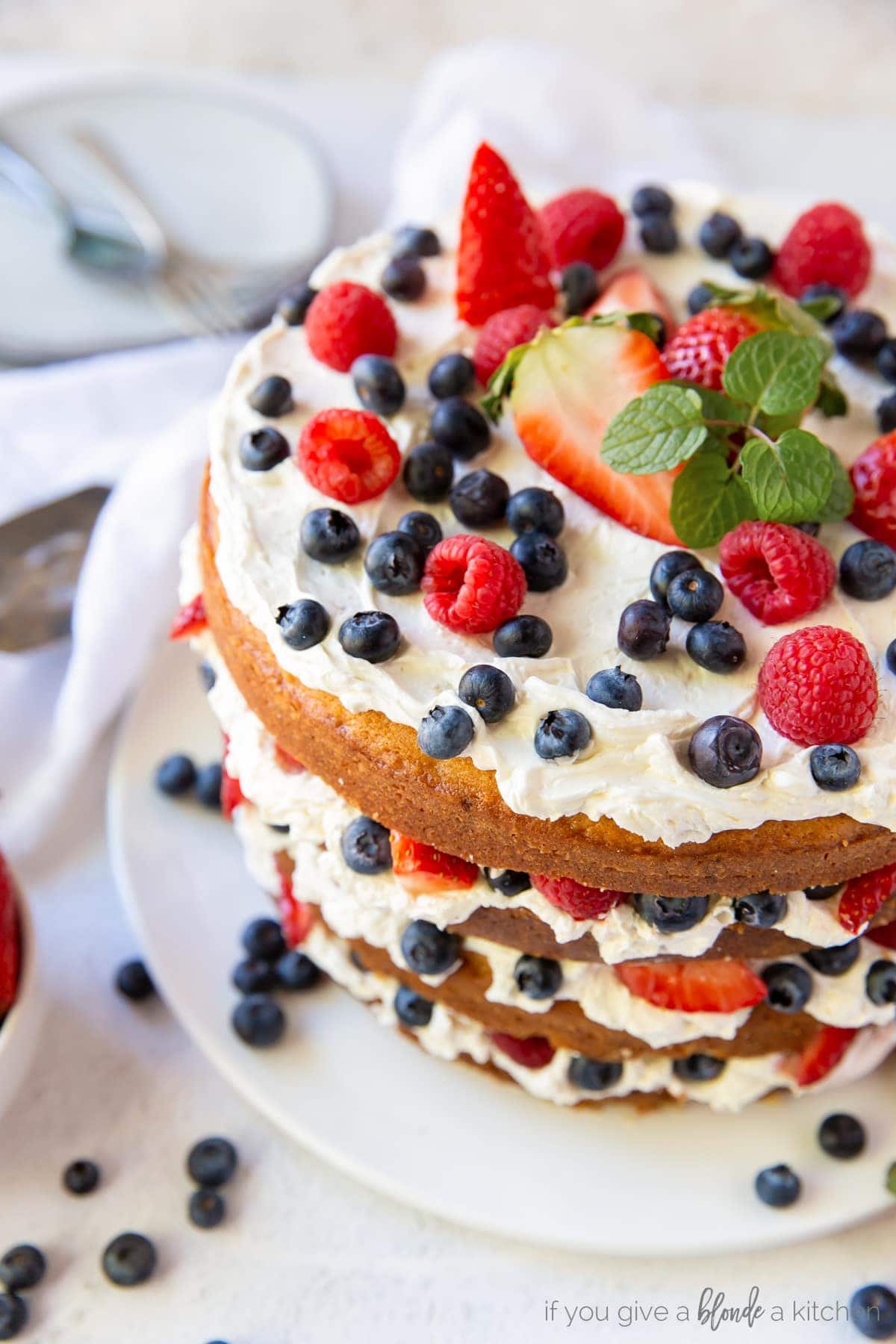 triple berry layer cake with swiss meringue buttercream and blueberries, raspberries and strawberries