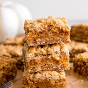 stack of pumpkin pie bars with oatmeal crumble and crust.