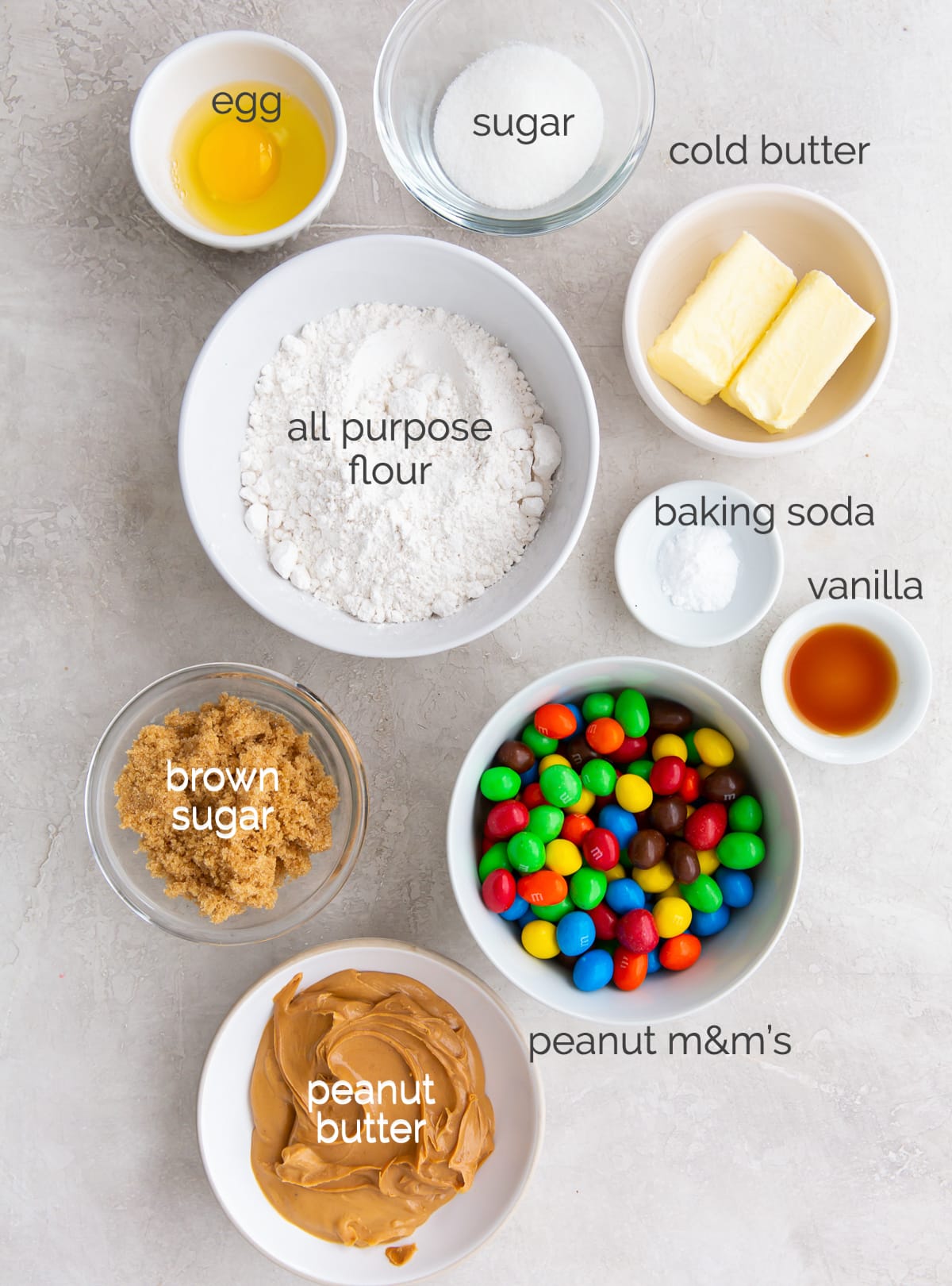 peanut m&m cookie ingredients in bowls labeled with text