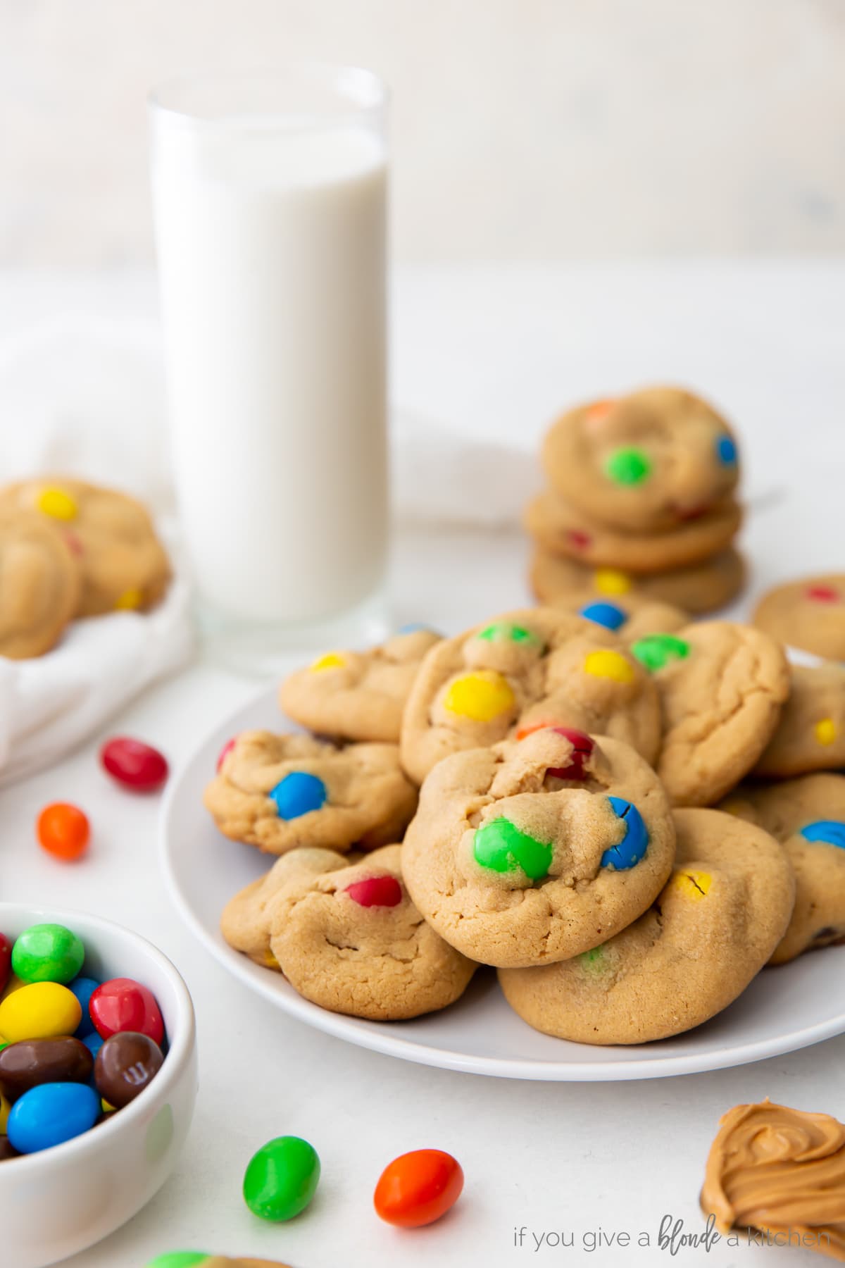 peanut M&M cookies on cookie sheet with bowl of colorful m&ms