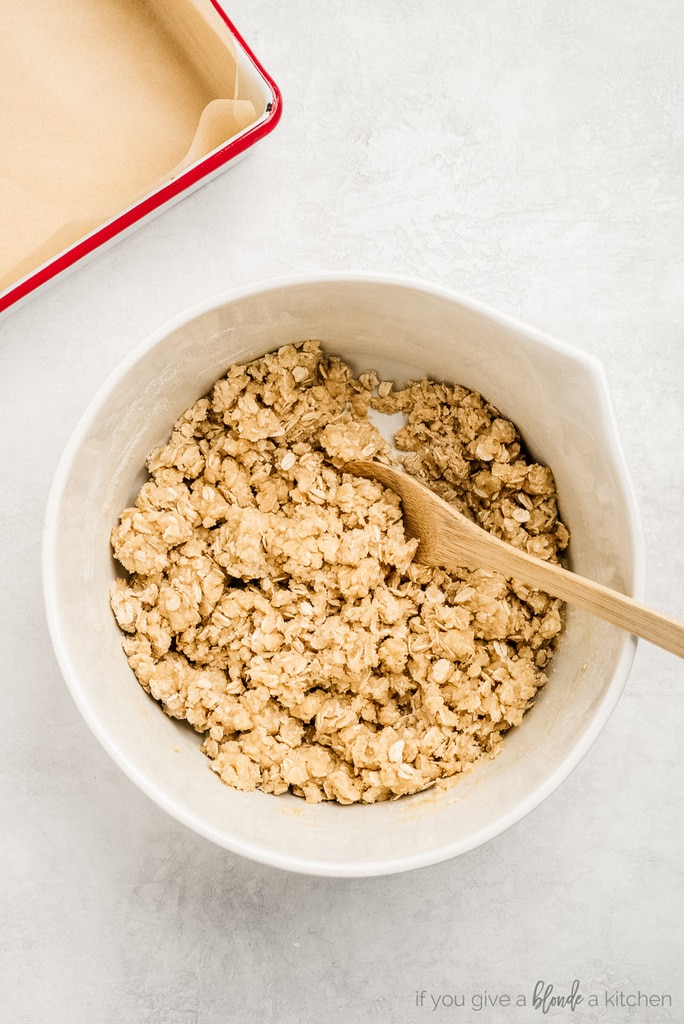 bowl of oat crumble topping with wooden spoon