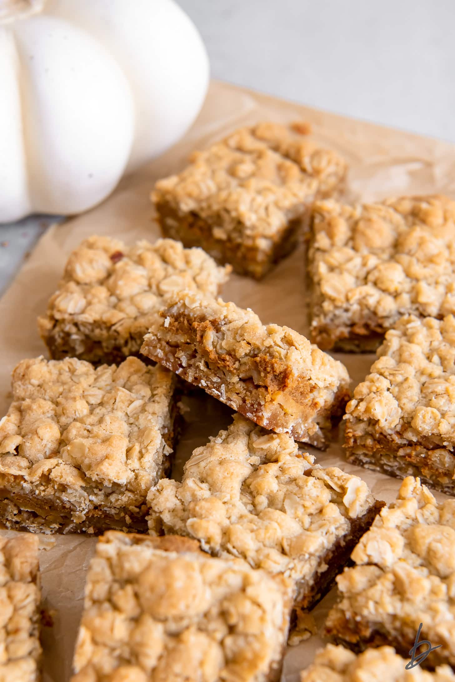 pumpkin pie bars with crumble topping and one bar propped up on other bars.