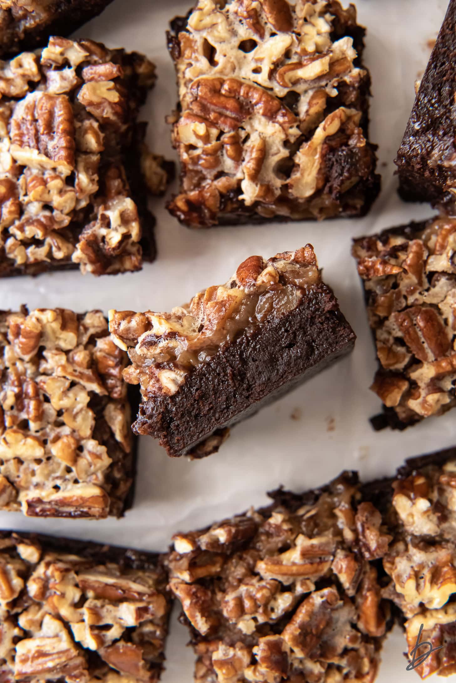 bourbon pecan pie brownie on its side showing gooey layers surrounded by more brownies.