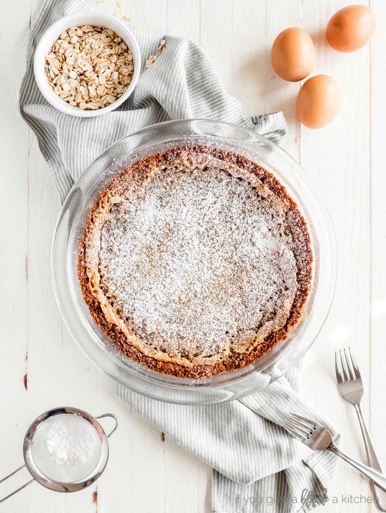 momofuku milk bar pie on stripe kitchen cloth next to rolled oats and eggs ingredients