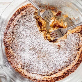 two forks in a pie dish with momofuku crack pie dusted with confectioners sugar