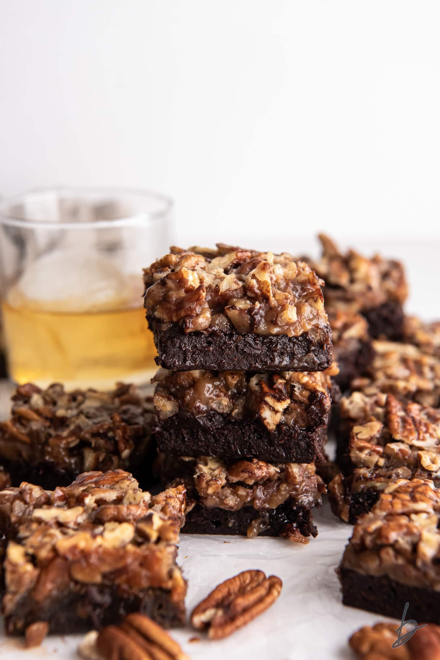 stack of three bourbon pecan pie brownies surrounded by more brownies.