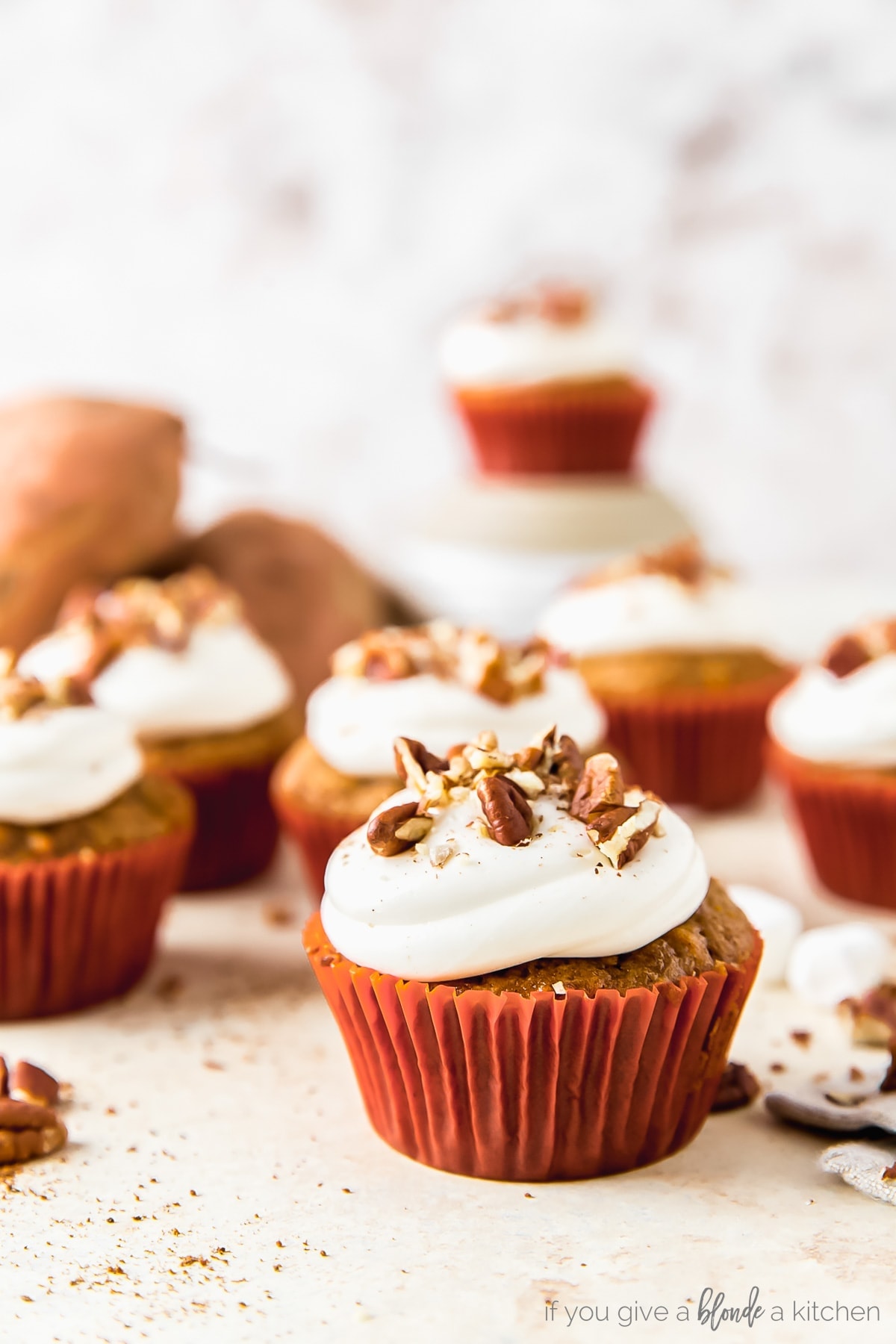 sweet potato cupcake topped with marshmallow frosting and chopped pecans
