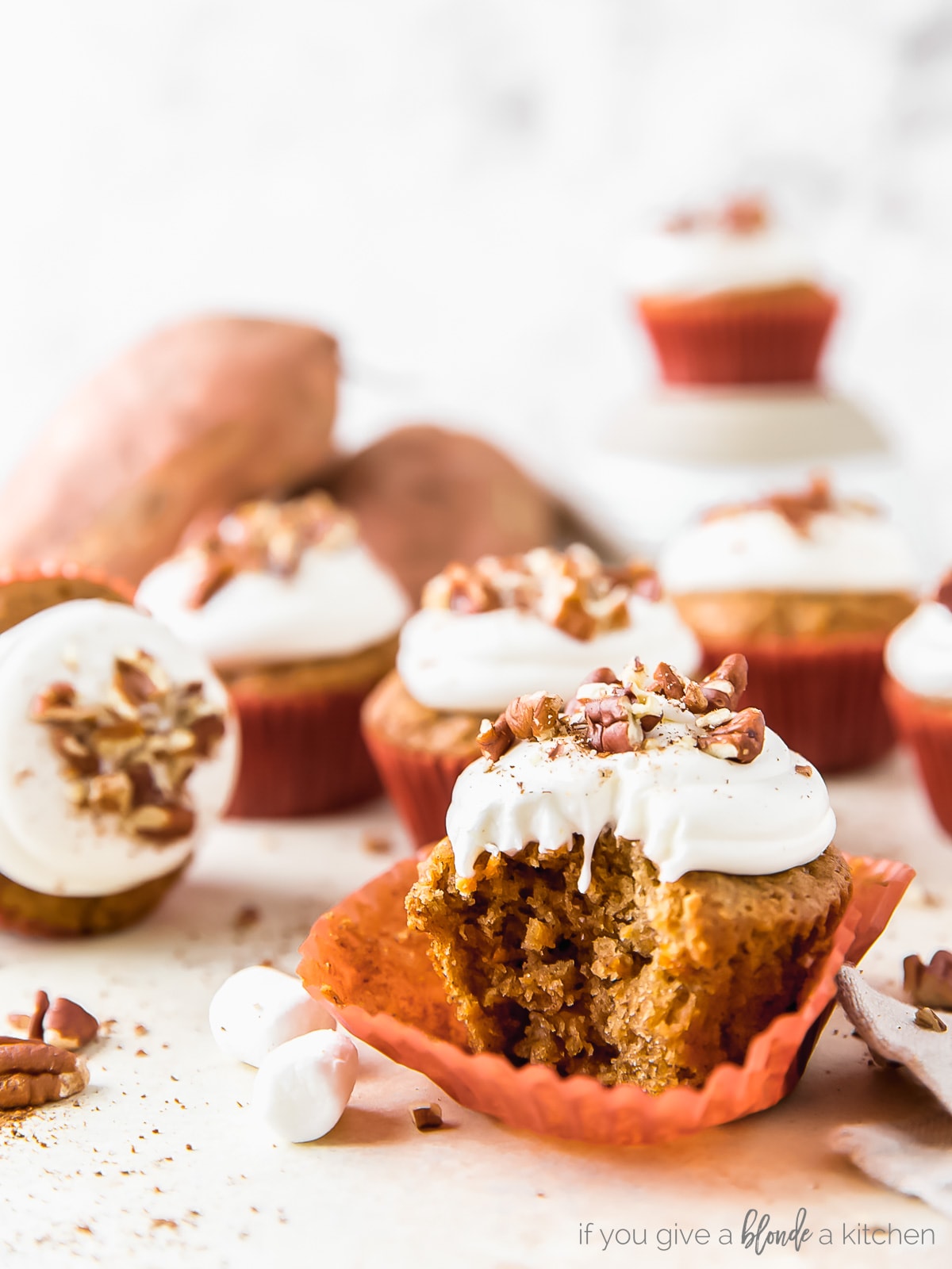 sweet potato cupcakes and marshmallow cream frosting topped with crushed pecans.