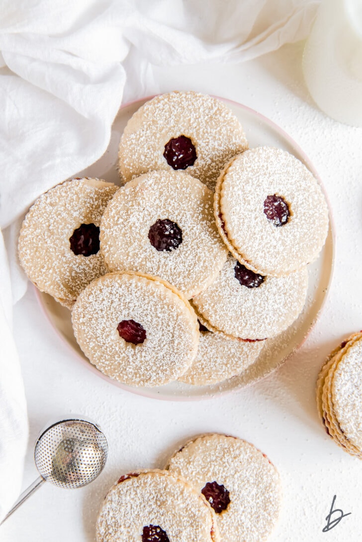 round plate with linzer cookies dusted with confectioners' sugar