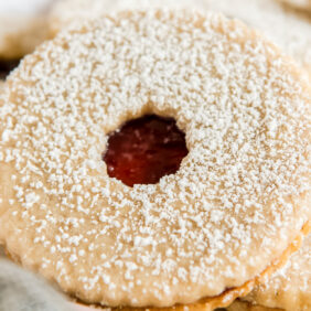 linzer cookie sandwich with circle hole showing raspberry jam inside