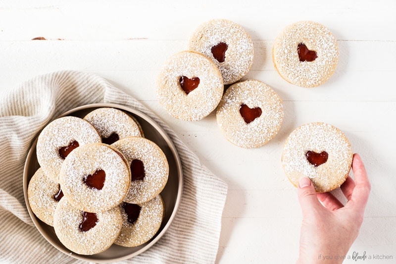 Linzer cookies with heart for Valentine's Day. Raspberry jam and confectioners' sugar. Cookie on plate withkitchen cloth