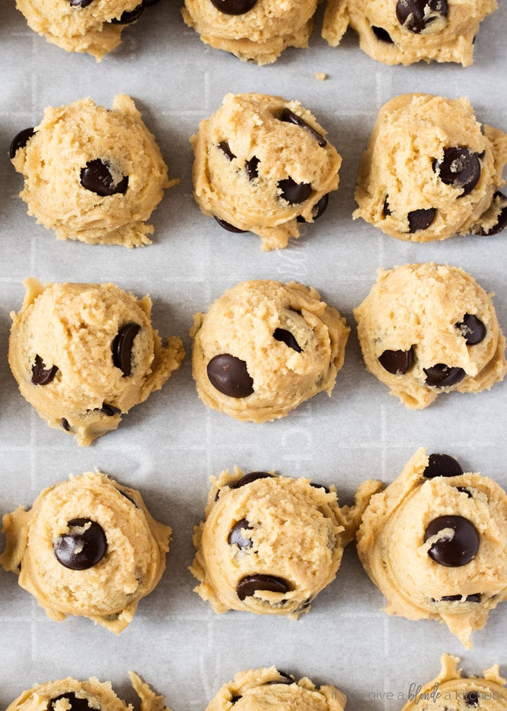 homemade chocolate chip cookie dough rolled into balls and scooped onto baking sheet