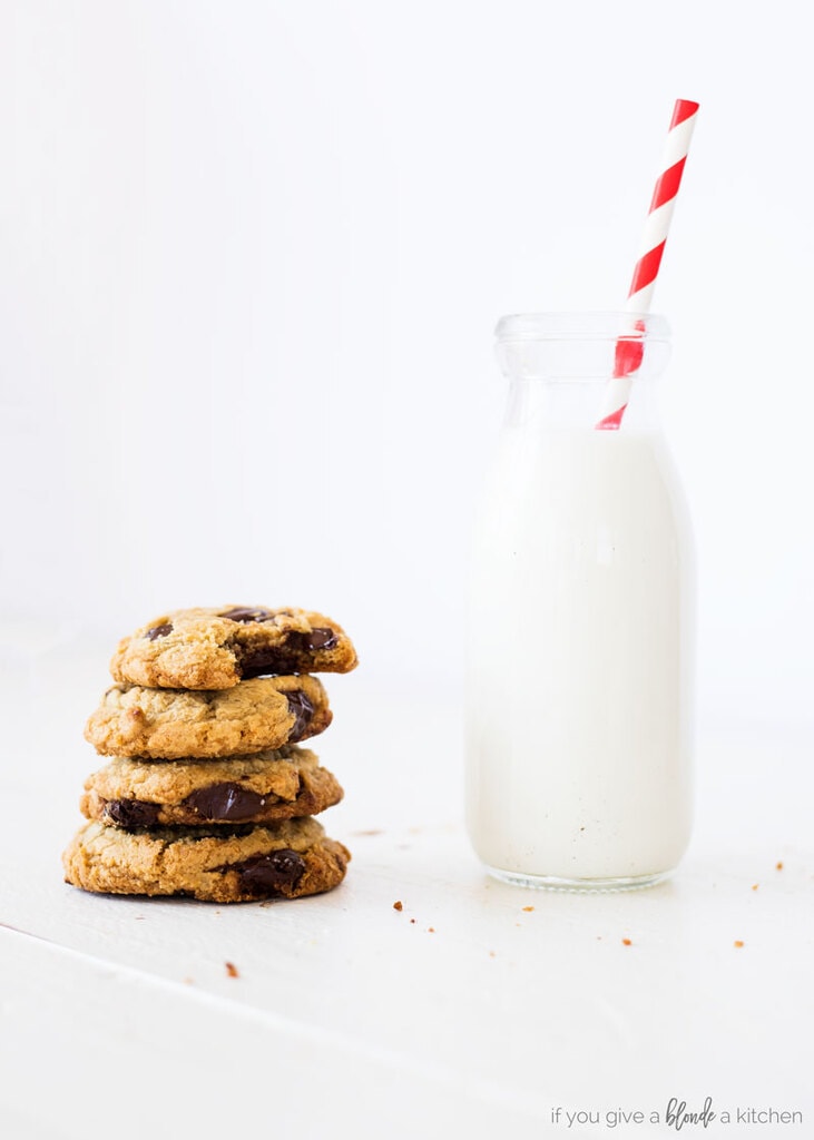 homemade chocolate chip cookies stack of cookies with glass of milk with red stripe straw