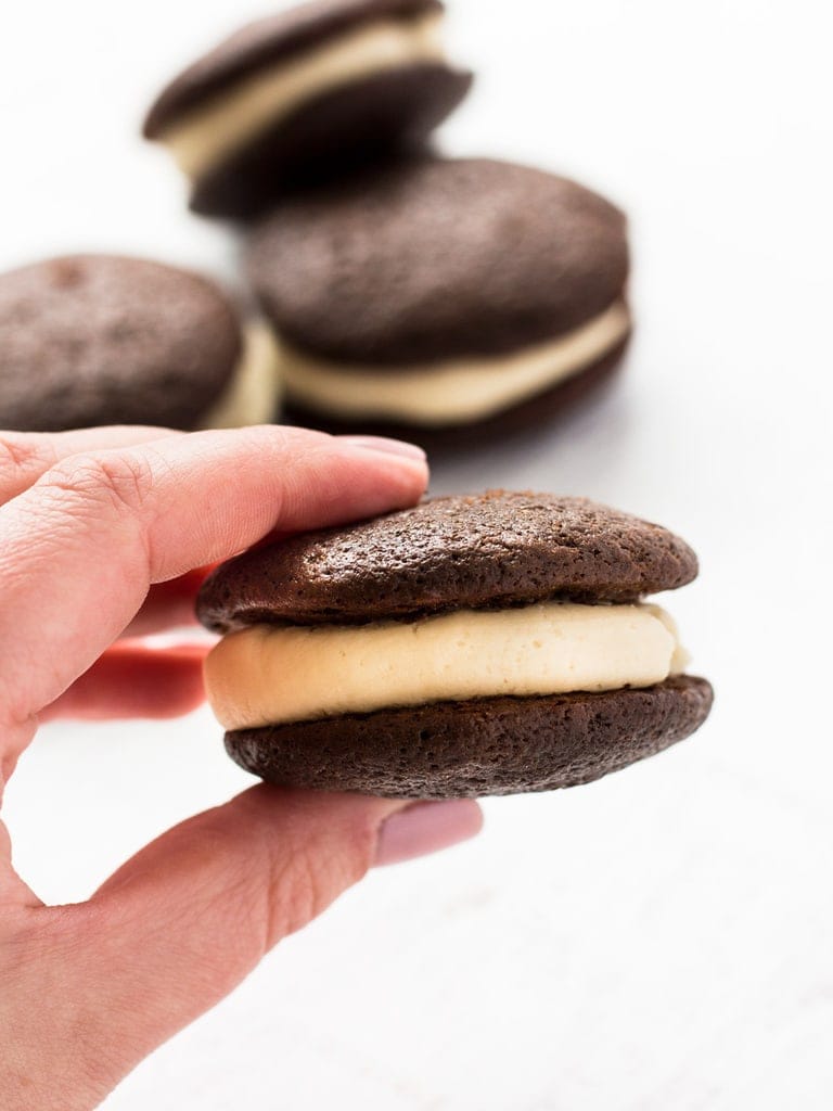 hand holding chocolate whoopie pie with baileys buttercream frosting