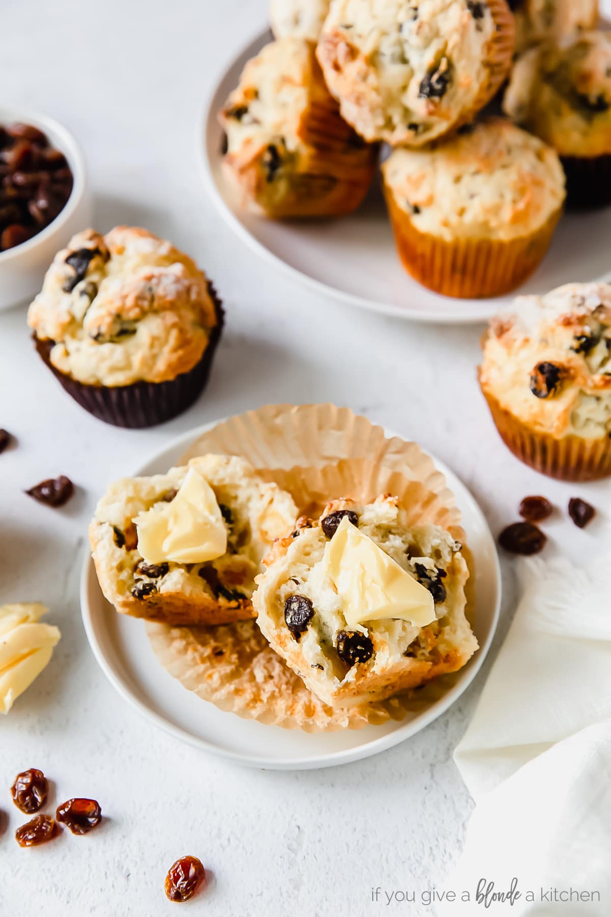 irish soda bread muffin cut in half on small plate with butter spread on muffin.