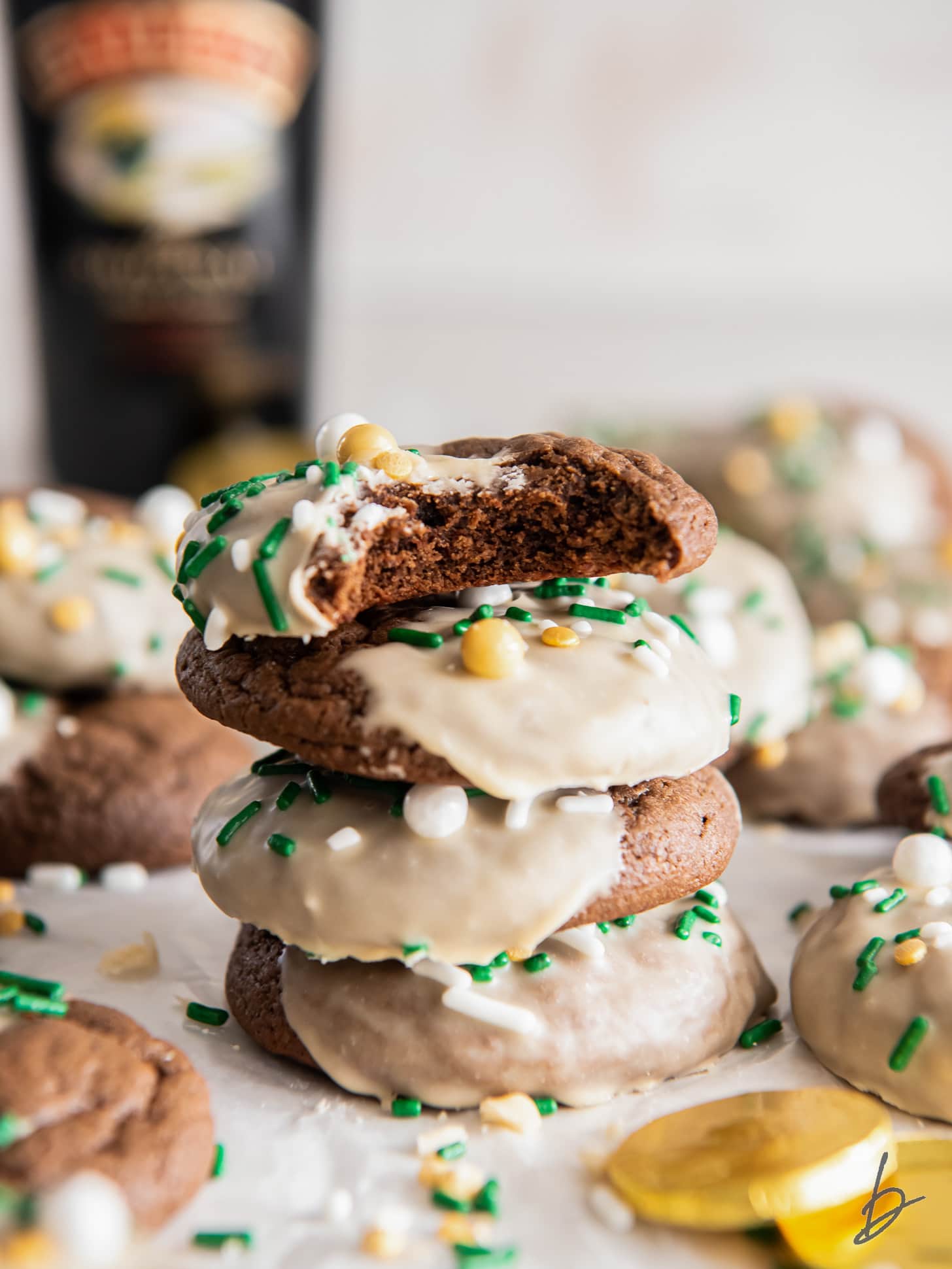 stack of bailey's chocolate cookies with icing and top cookie with a bite.