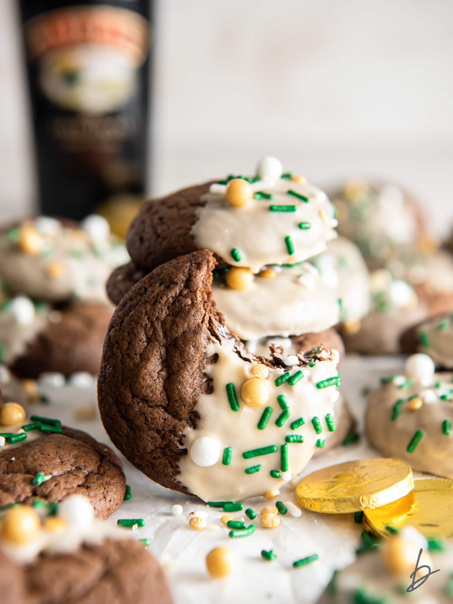 chewy bailey's irish cream cookie with a bite leaning against stack of cookies.