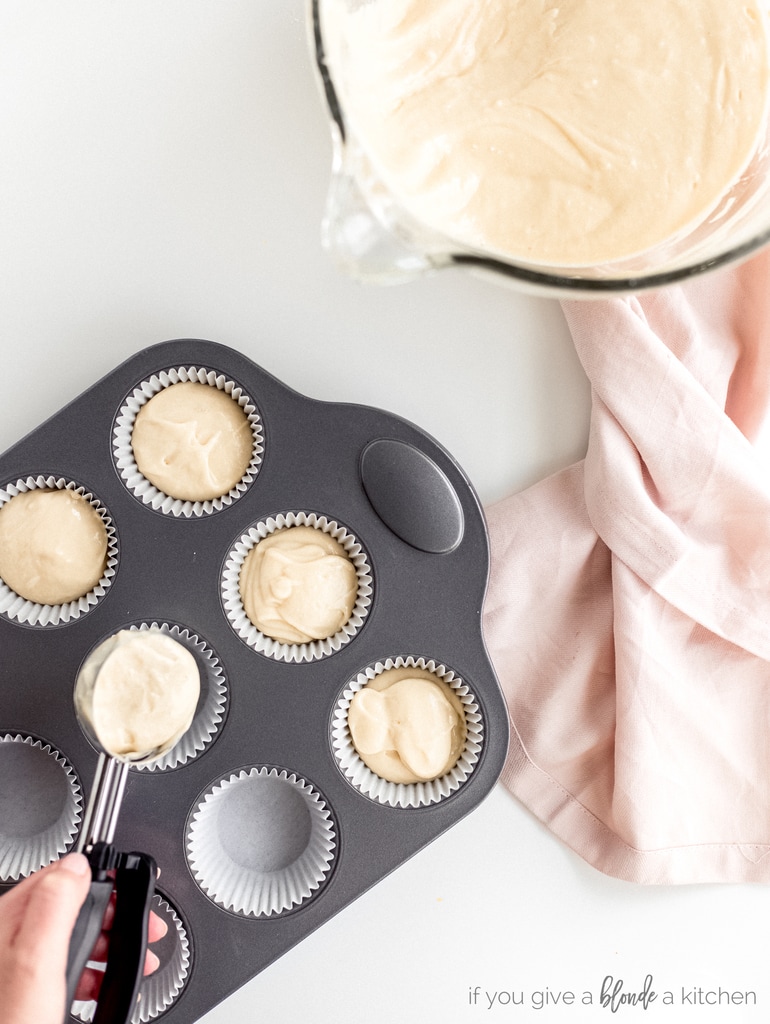 cupcake batter spooned into prepared muffin tin