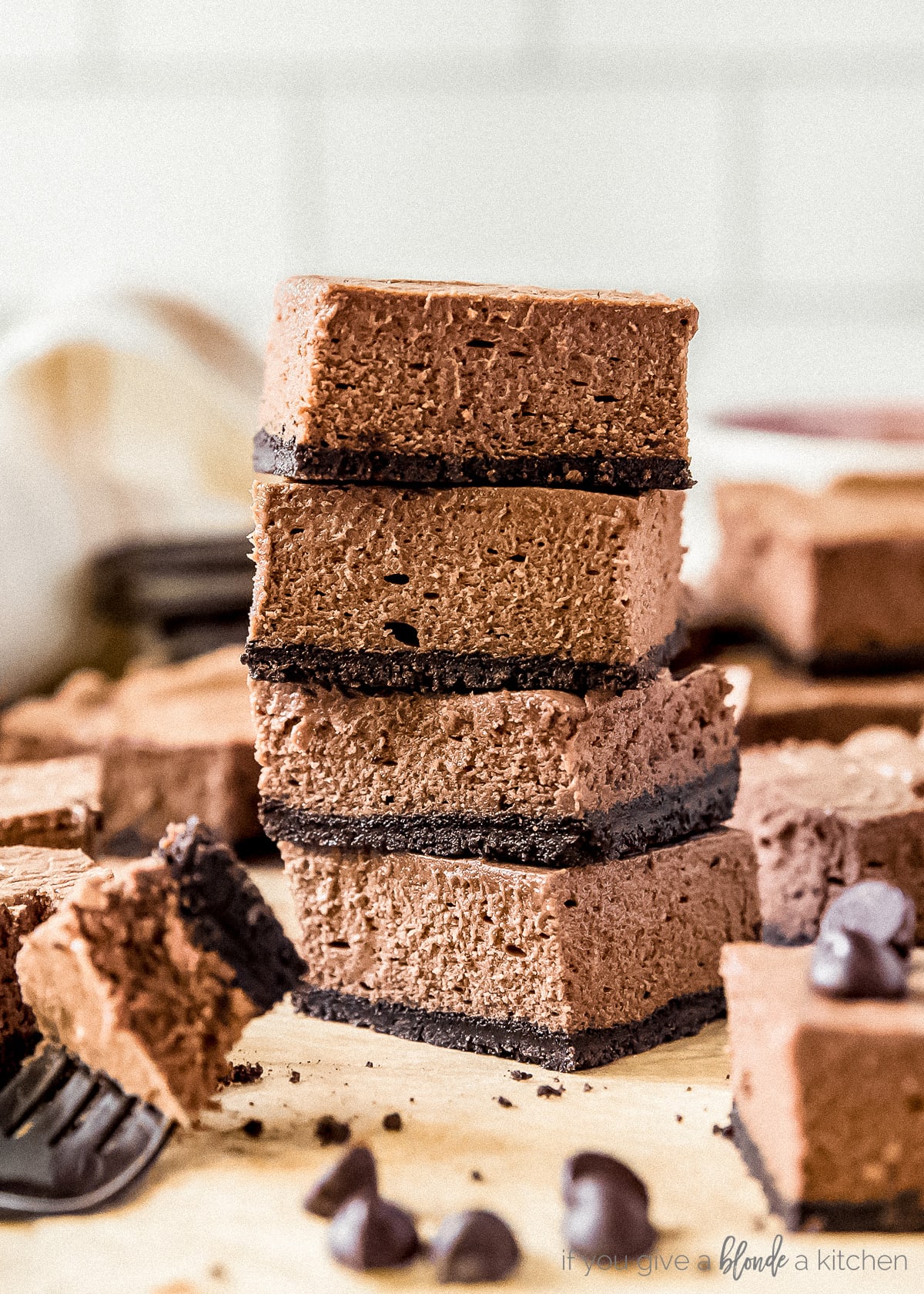 stack of four chocolate cheesecake bars with oreo crust.