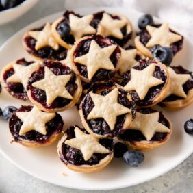 plate of mini blueberry pies with star-shape crusts on top