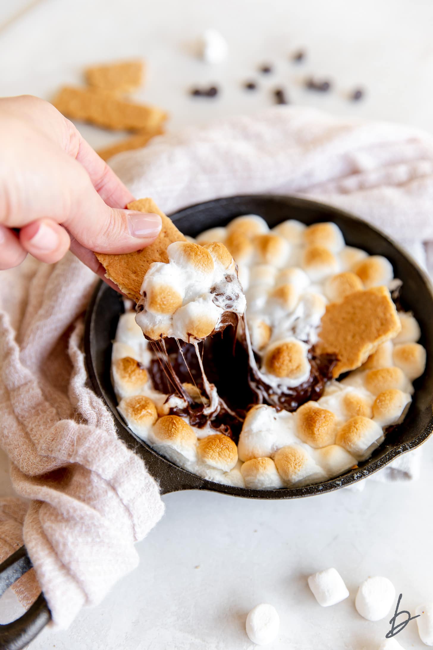 graham cracker pulling smores dip out of skillet