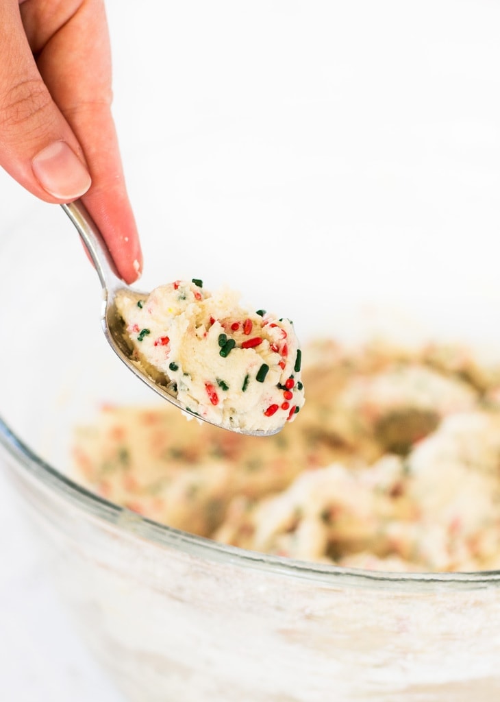 hand holding spoon of edible sugar cookie dough