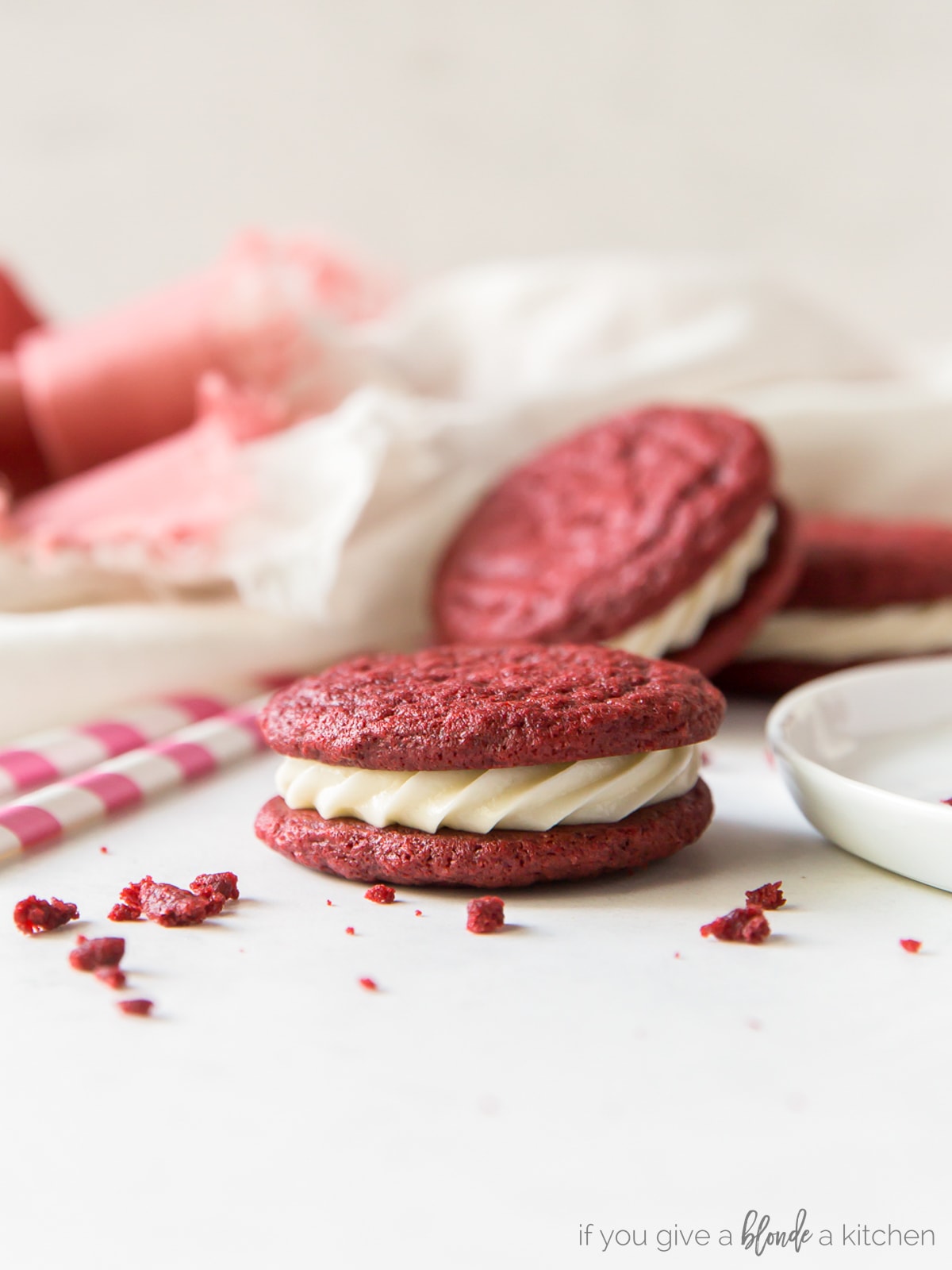 Red velvet sandwich cookies are perfect for Christmas time! Save this recipe for Valentine's Day too. | www.ifyougiveablondeakitchen.com