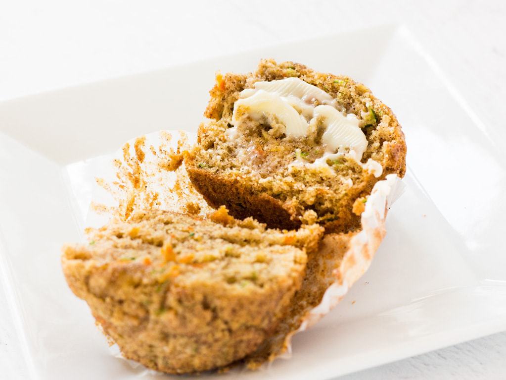 carrot zucchini muffin cut in half with butter spread in center