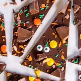 pieces Halloween candy bark topped with sprinkles, candy eyes, Reese's and Kit Kats
