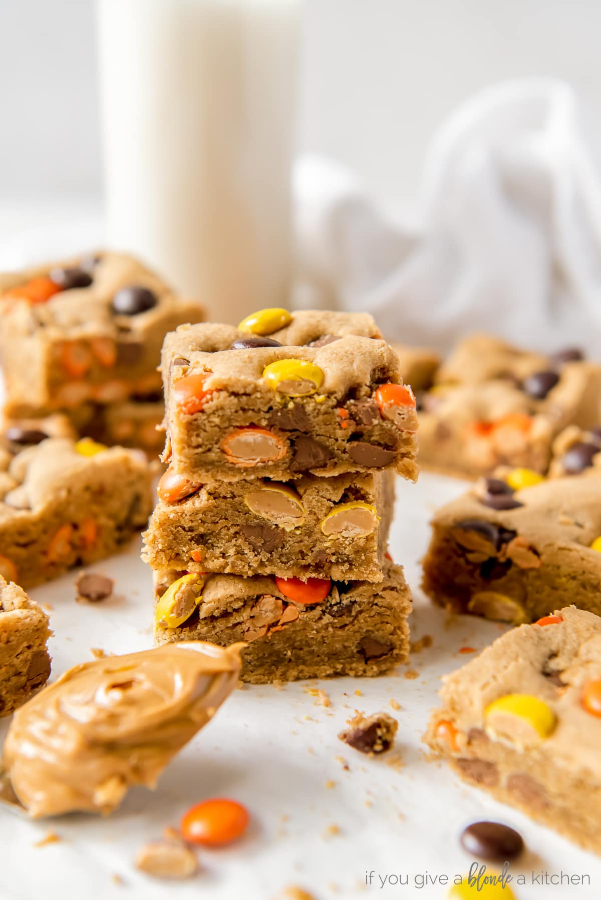 three reeses pieces peanut butter blondies stacked on top of each other