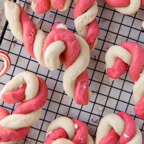 red and white twist candy cane cookies on black wire cooling rack