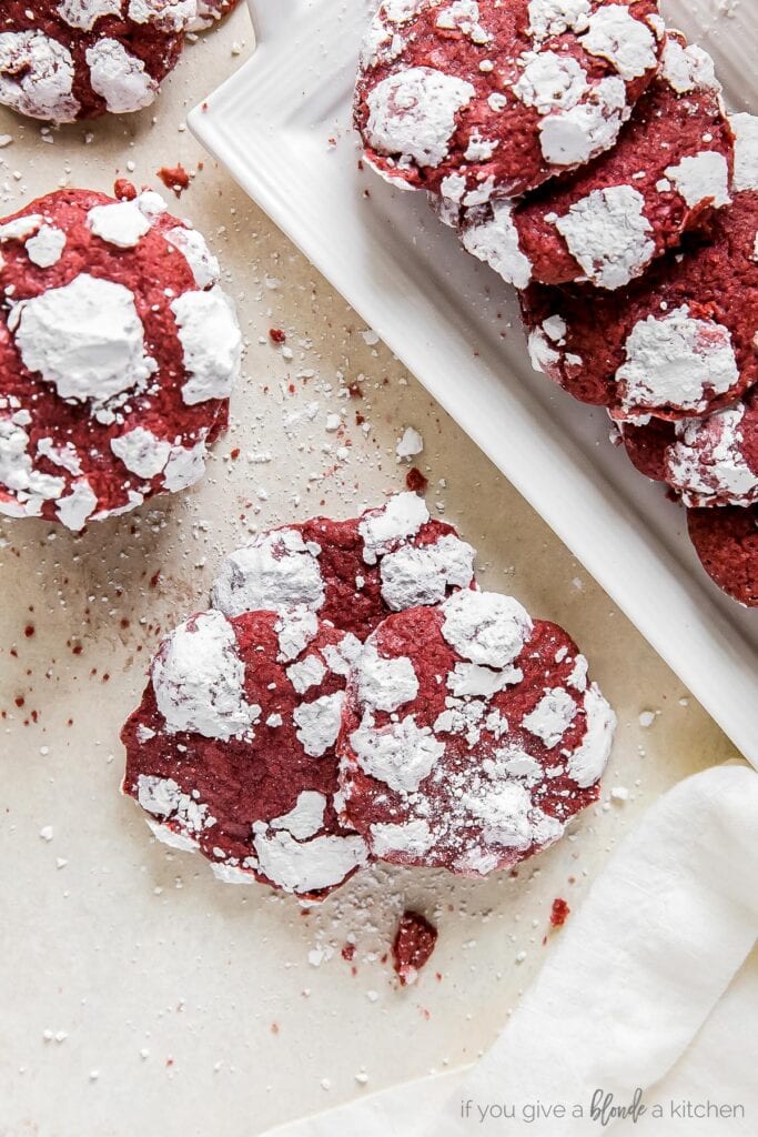 red velvet crinkle cookies on surface and on white rectangle plate