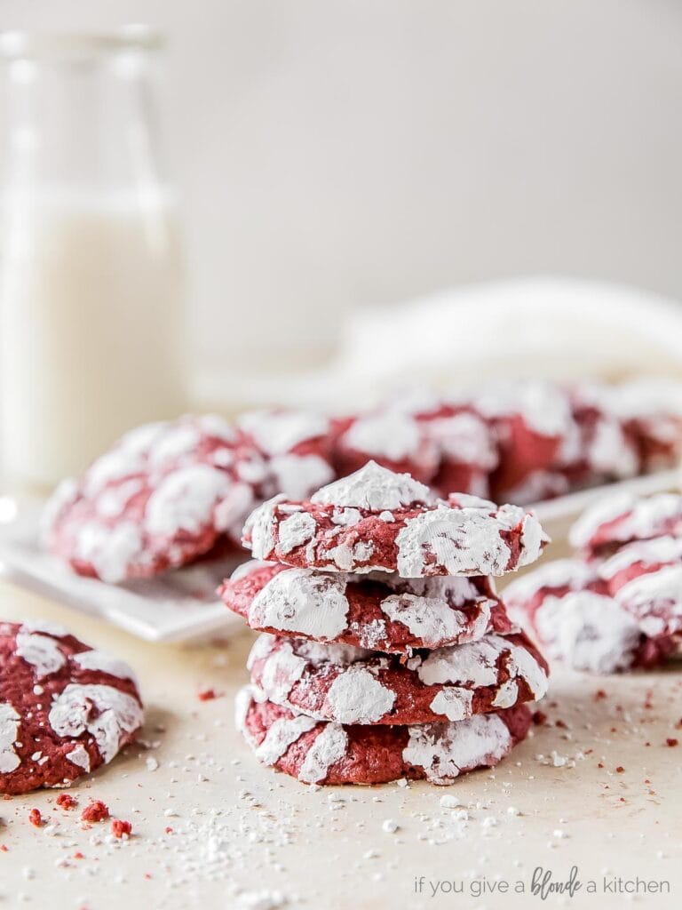 stack of four red velvet crinkle cookies with powdered sugar