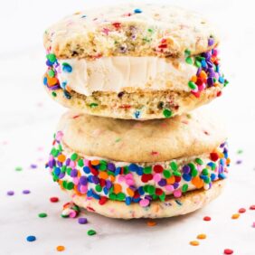 Birthday cake ice cream sandwiches are an easy homemade dessert for summer. Use rainbow sprinkles and homemade sugar cookies to make this sweet treat! | www.ifyougiveablondeakitchen.com