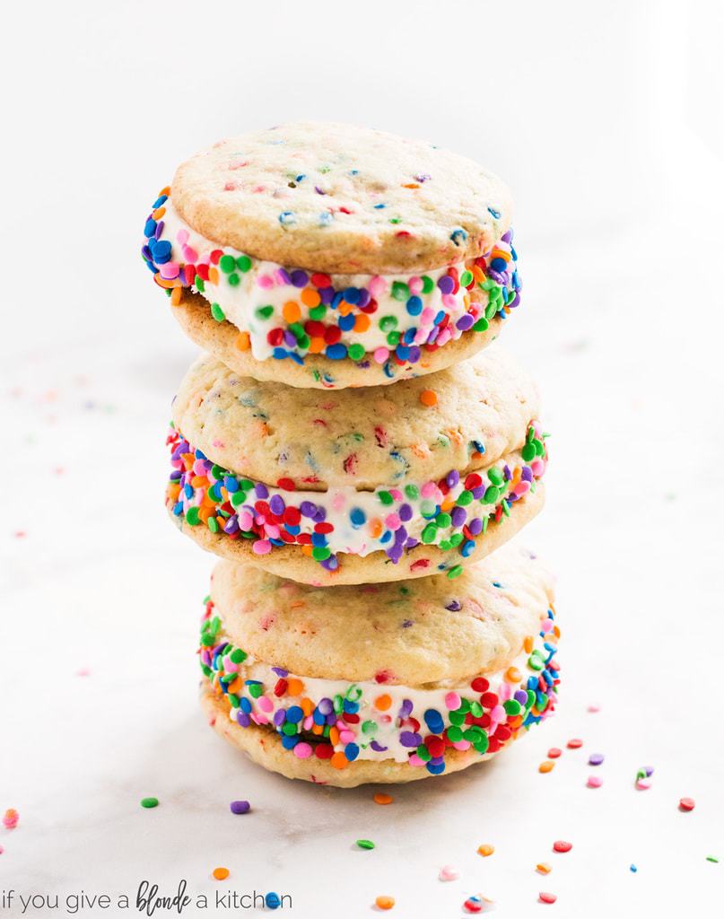 Birthday cake ice cream sandwiches are the perfect dessert on a special day! Ice cream is sandwiched between homemade sprinkle sugar cookies for a homemade treat! | www.ifyougiveablondeakitchen.com