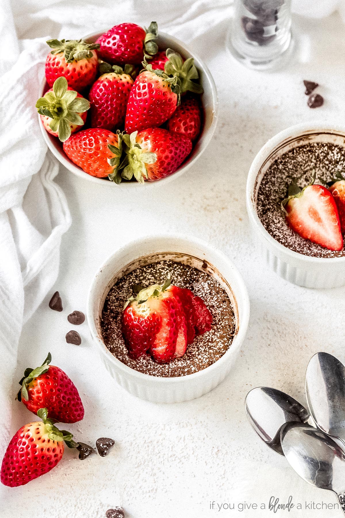 Mini flourless chocolate cake in ramekins with sliced strawberries