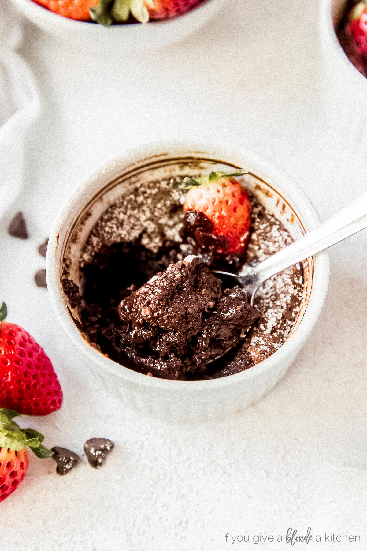Mini flourless chocolate cake with spoon serving and strawberries