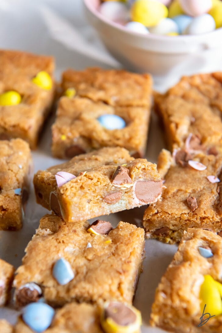 mini egg easter blondie leaning on top of another blondie showing chopped Cadbury mini eggs inside