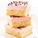 Stack of sugar cookie bars with pink frosting and sprinkles