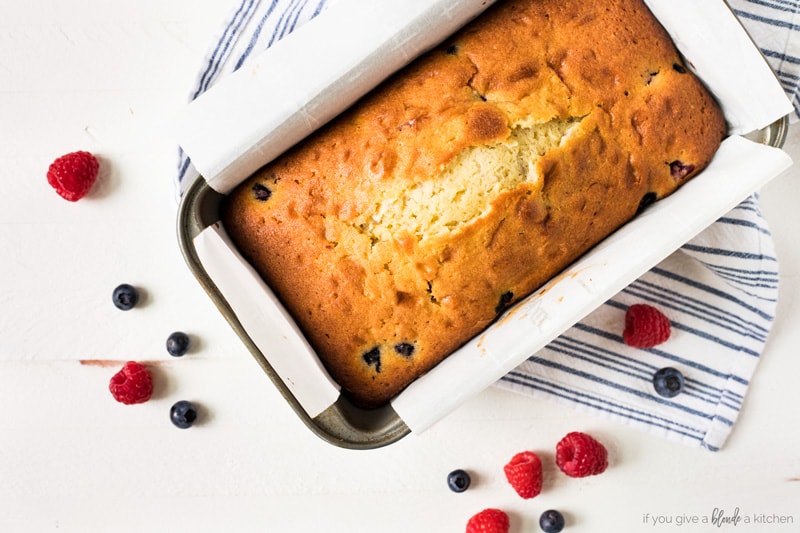 Blueberry raspberry pound cake in pan with parchment paper overhead photo