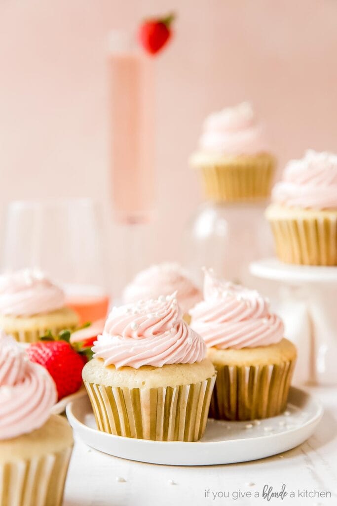 moscato cupcakes with pink frosting on white round plate