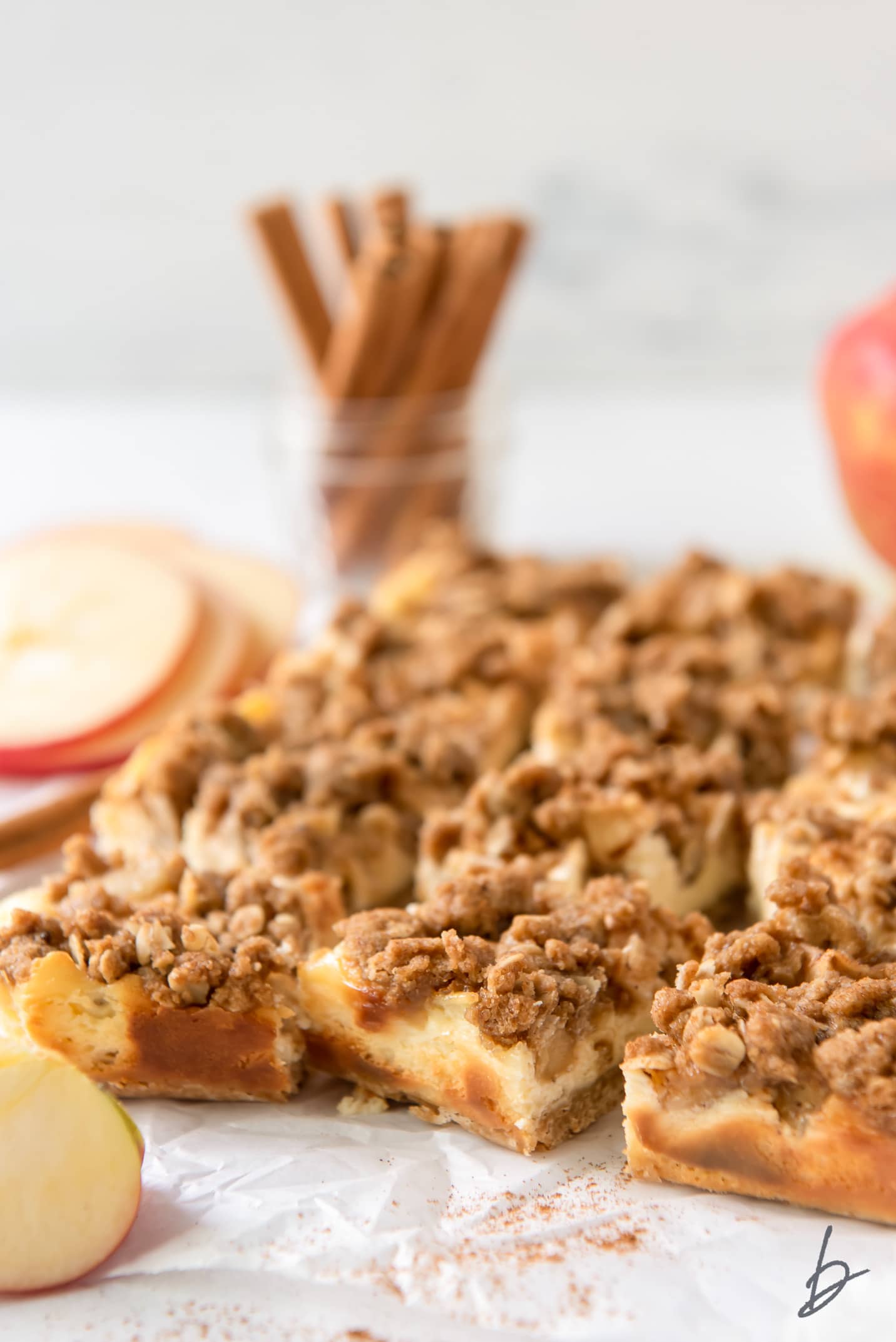 apple cheesecake bars with streusel on parchment paper