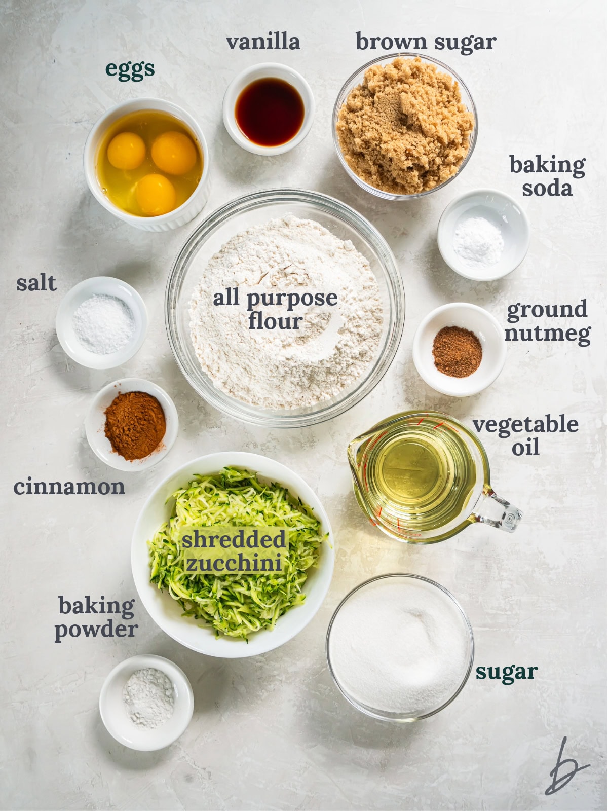 tabletop with bowls of ingredients to make cinnamon zucchini bread.
