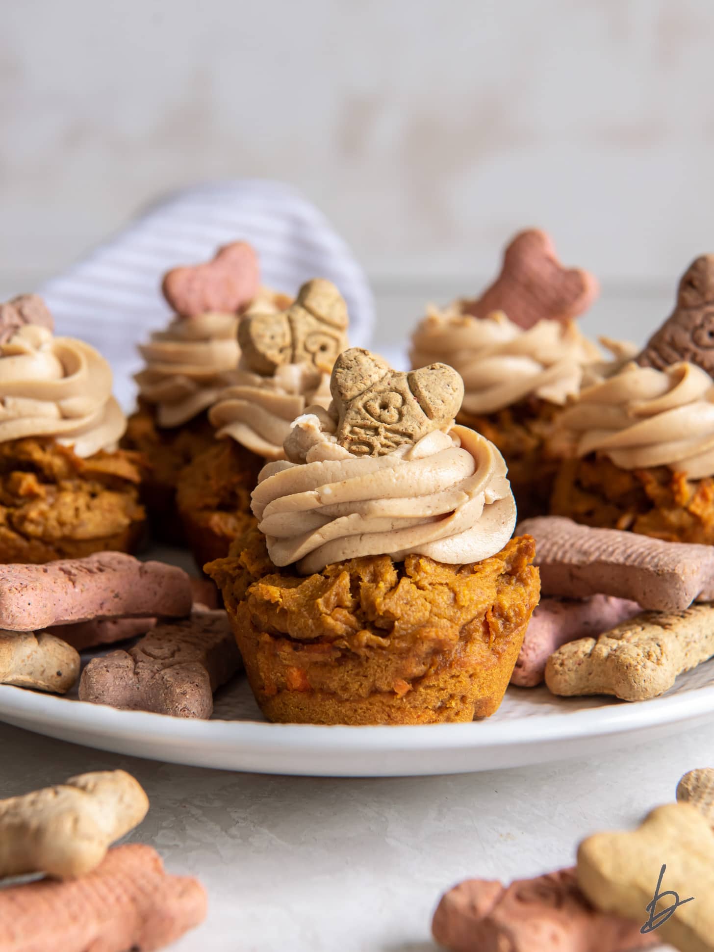 pupcakes with frosting on a plate with biscuits.