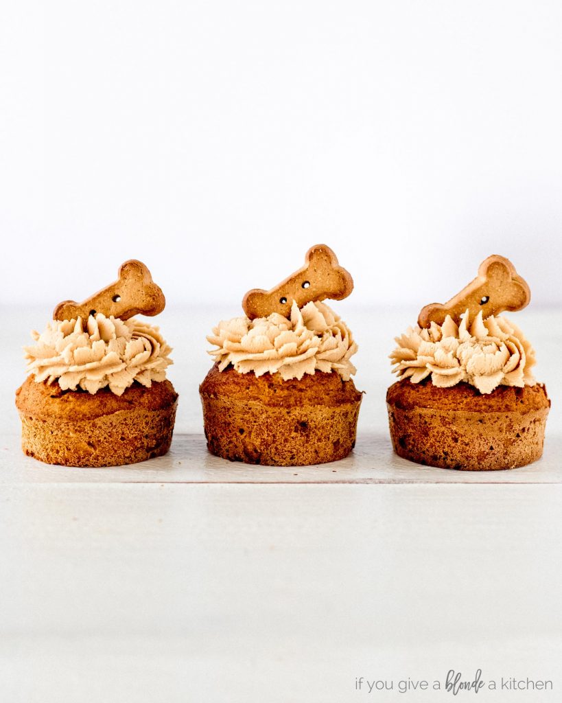 pumpkin peanut butter pupcakes dog biscuits lined up with frosting