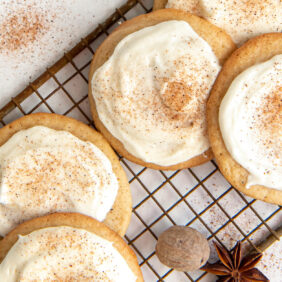 frosted eggnog cookies dusted with nutmeg on vintage wire cooling rack