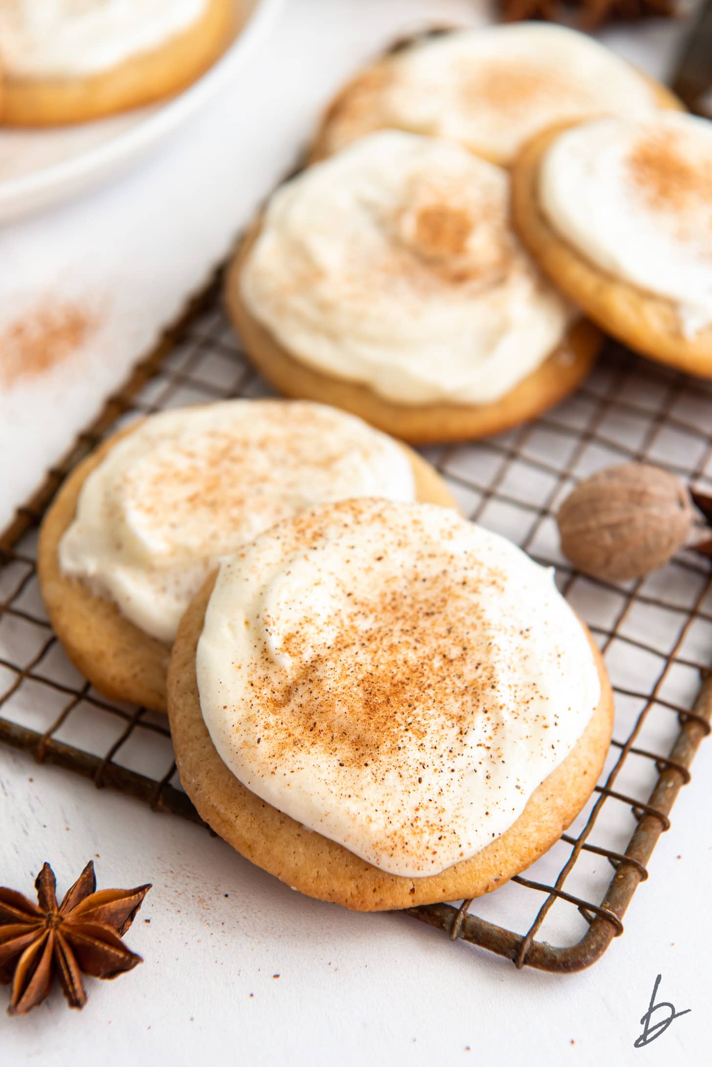 frosted eggnog cookies dusted with nutmeg on small vintage cooling rack.