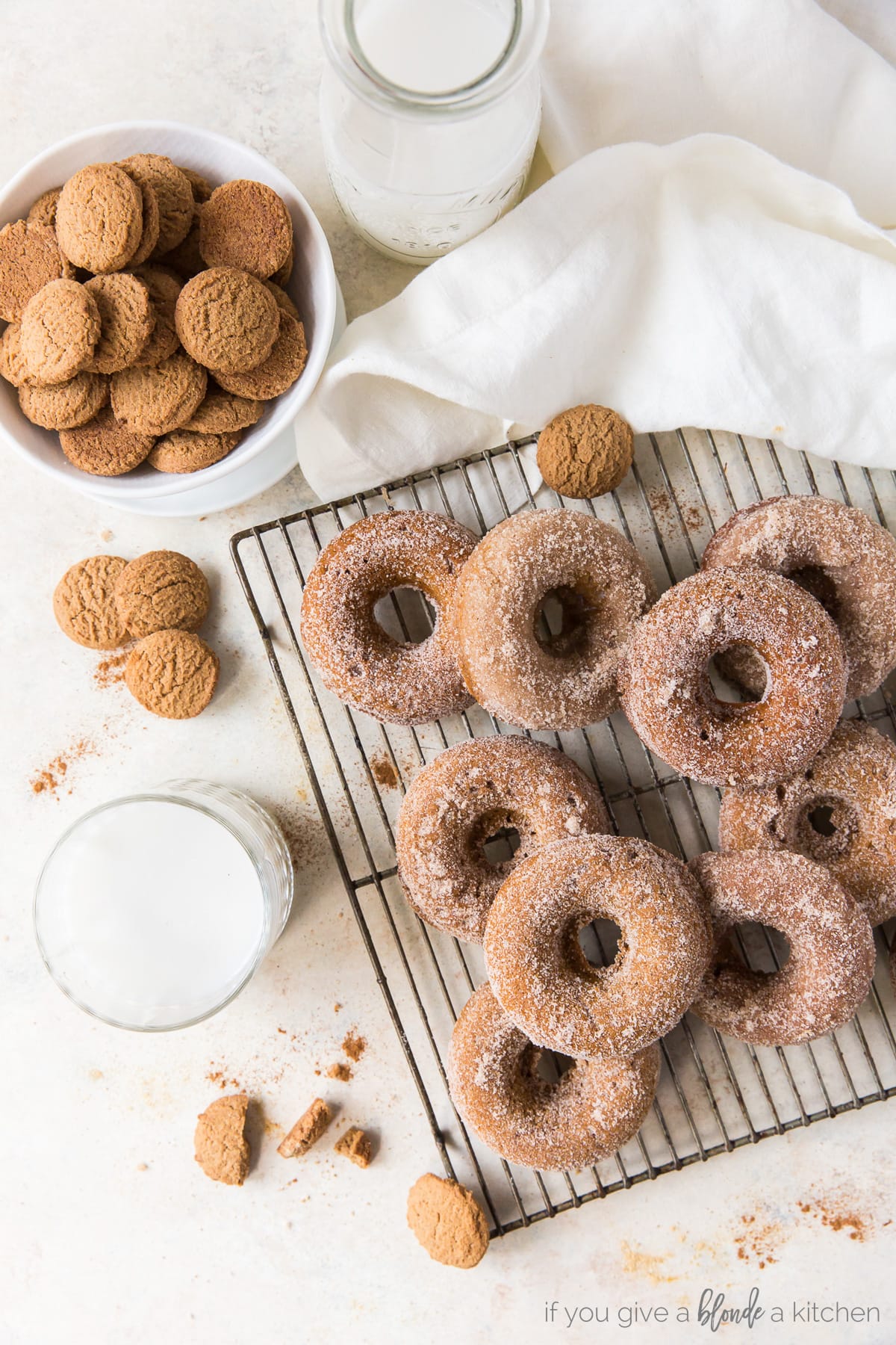 gingerbread donuts with cinnamon sugar on wire cooling rack next to bowl of small ginger cookies