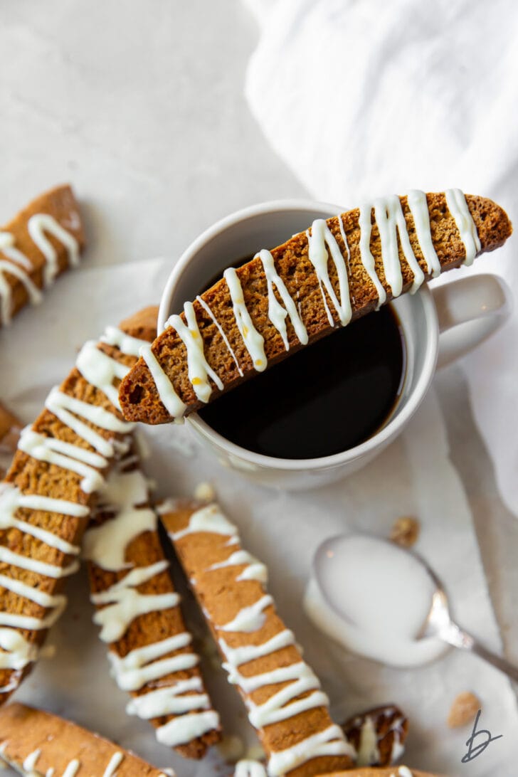 gingerbread biscotti resting on top of mug filled with coffee