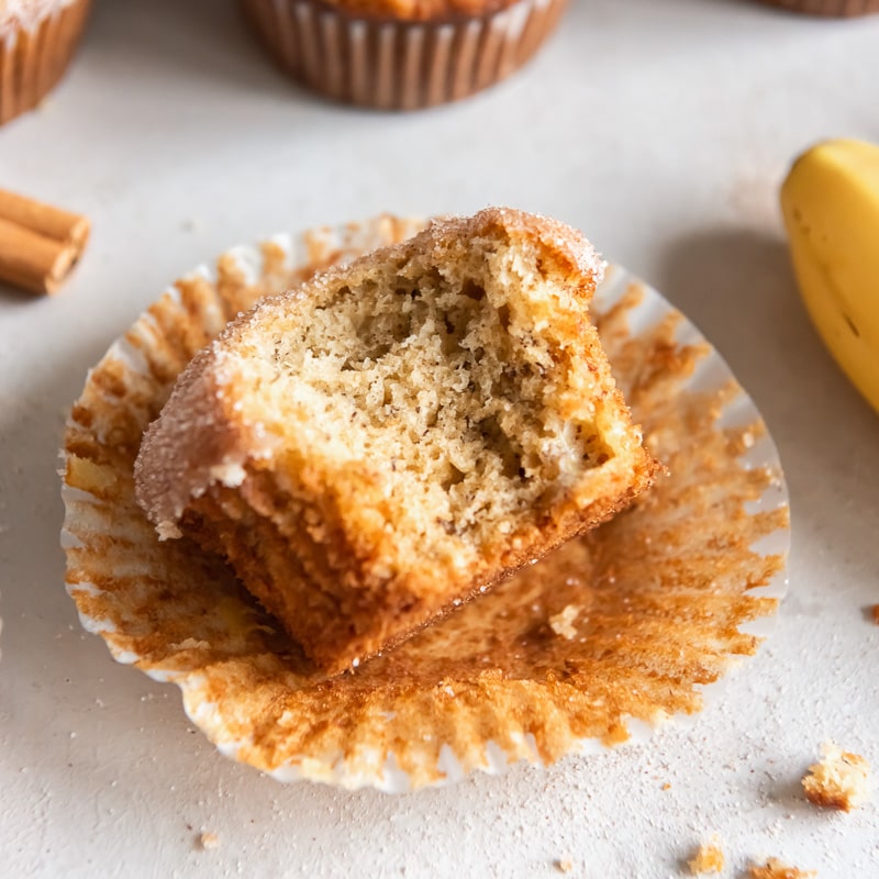 banana muffin with bite on paper muffin liner.